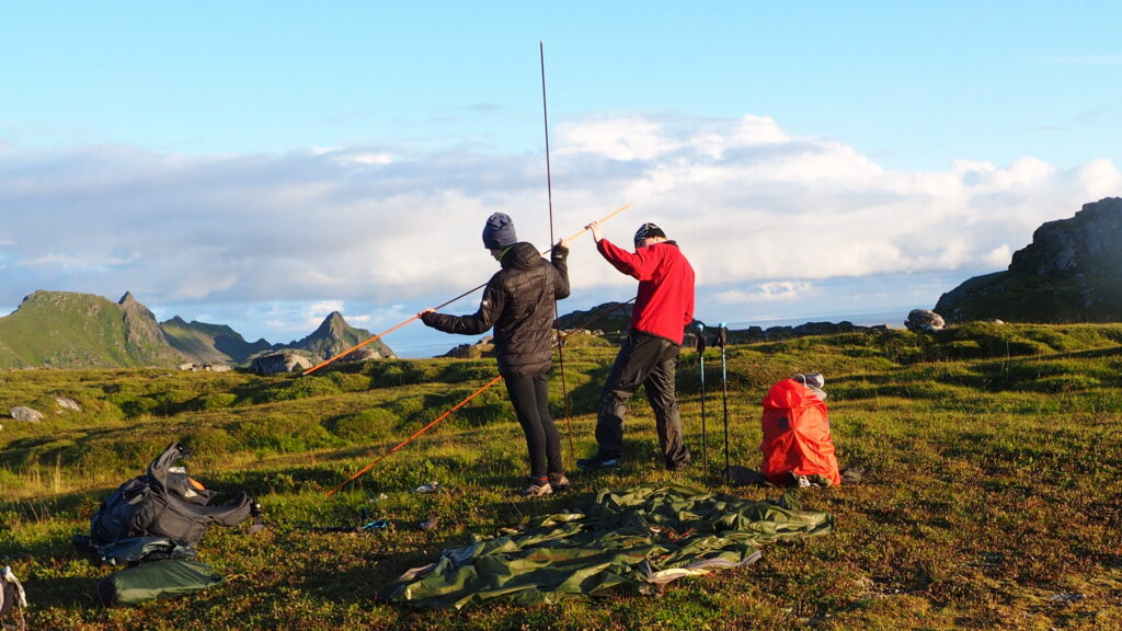 two persons Setting up the tent, Lofoten, sunset