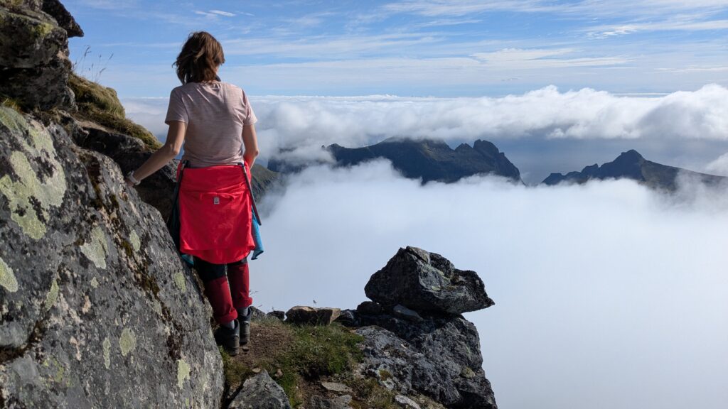 woman standing above the clouds, Hermannsdalstinden, Lofoten, Norway