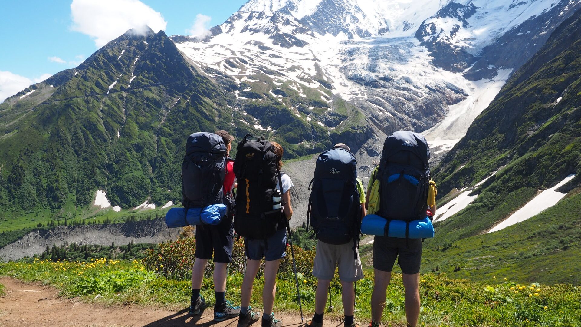 4 persons with big backpacks, a family, looking at Bionnassay Glacier, Tour du Mont Blanc