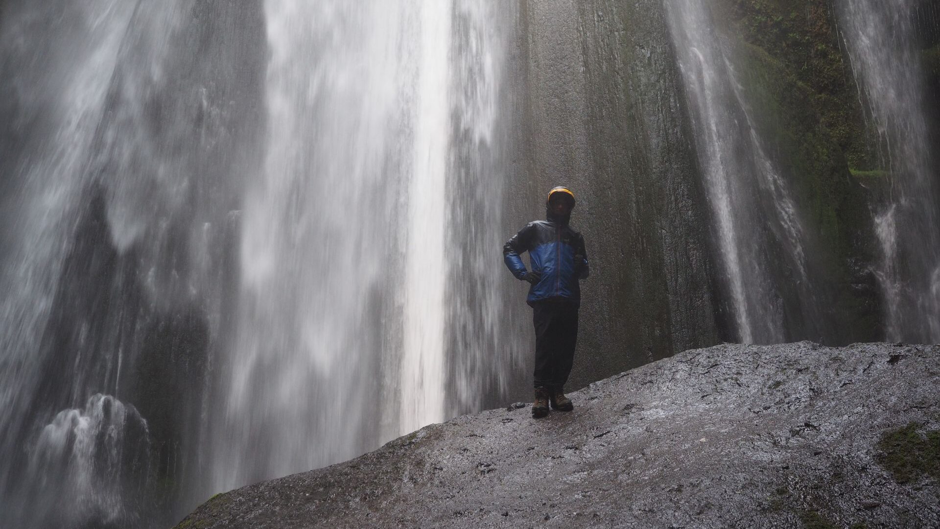 a person standing near the waterfall, Iceland