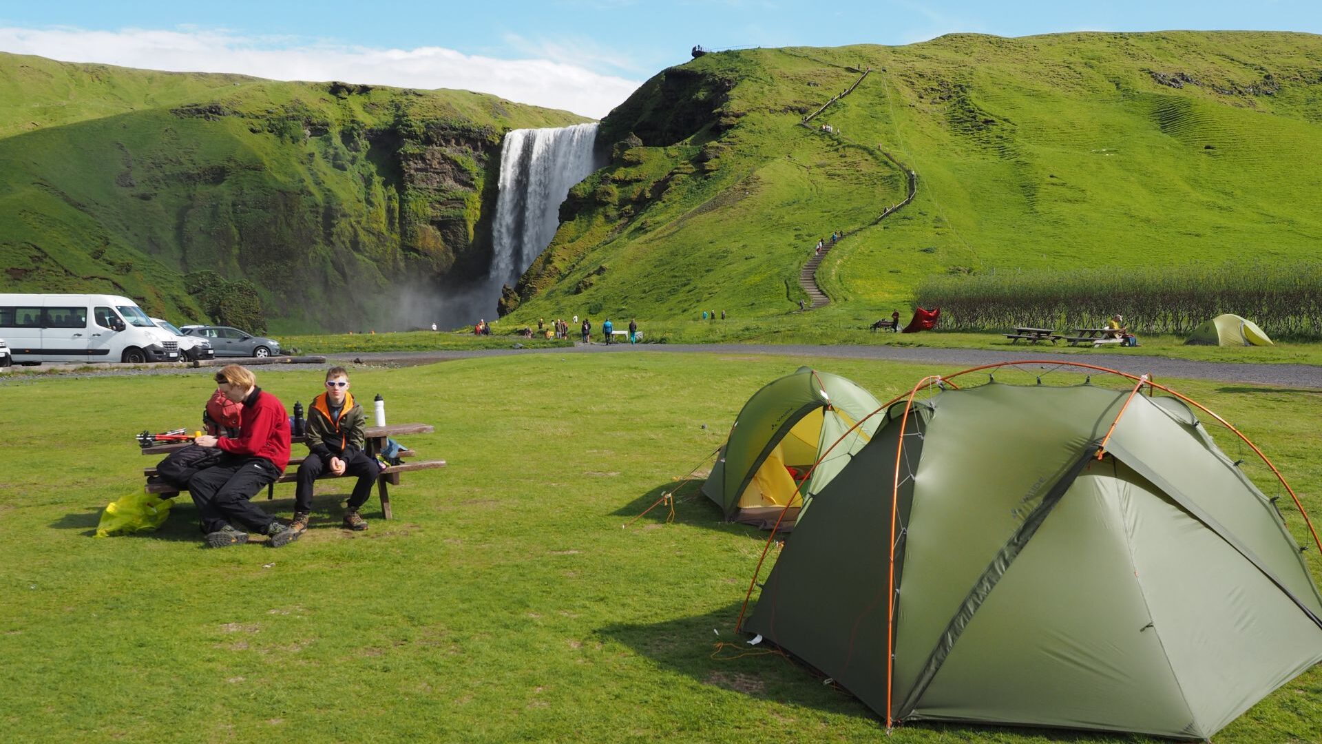 Skógafoss campsite, two tents and teenagers sitting nearby, Iceland