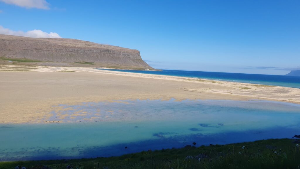 Turquoise lagoon and golden sands at Rauðasandur Beach in the Westfjords.